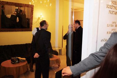 Bivši direktor Milan Predan se pogovarja z nekdanjo zvezdo Večerovih naslovnic, Janezem Janšo. Opazuje ju glavni in odgovorni urednik Tomaž Ranc.